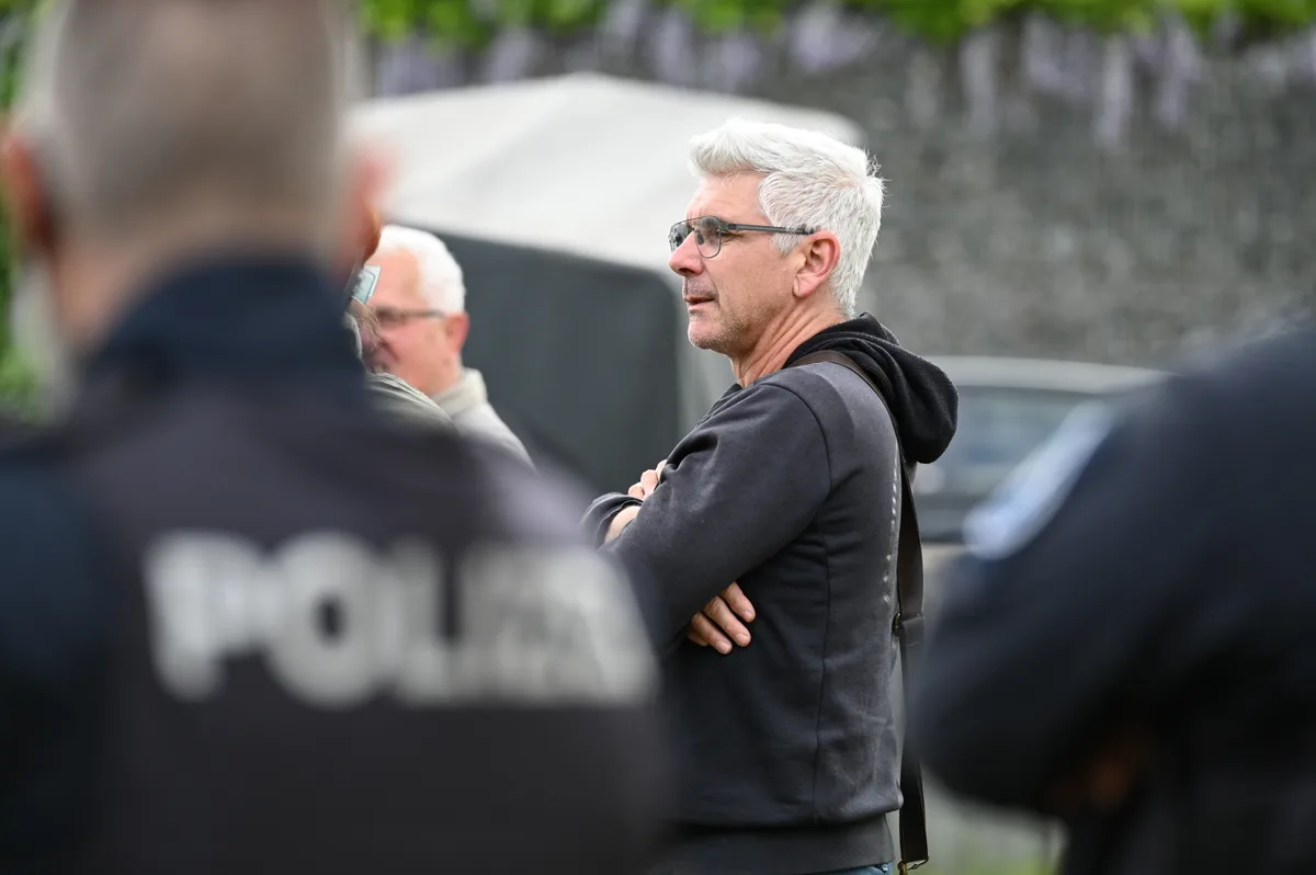 Man sieht zwei Männer und zwei Polizisten.